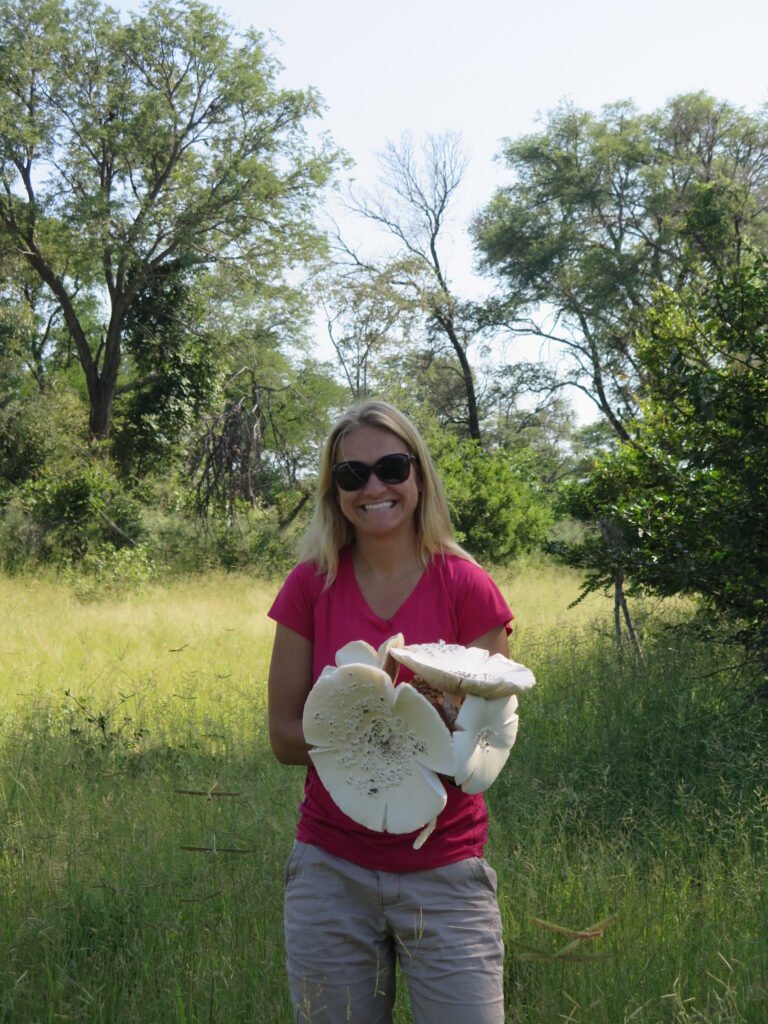 Girl holding giant mushrooms in Botswana